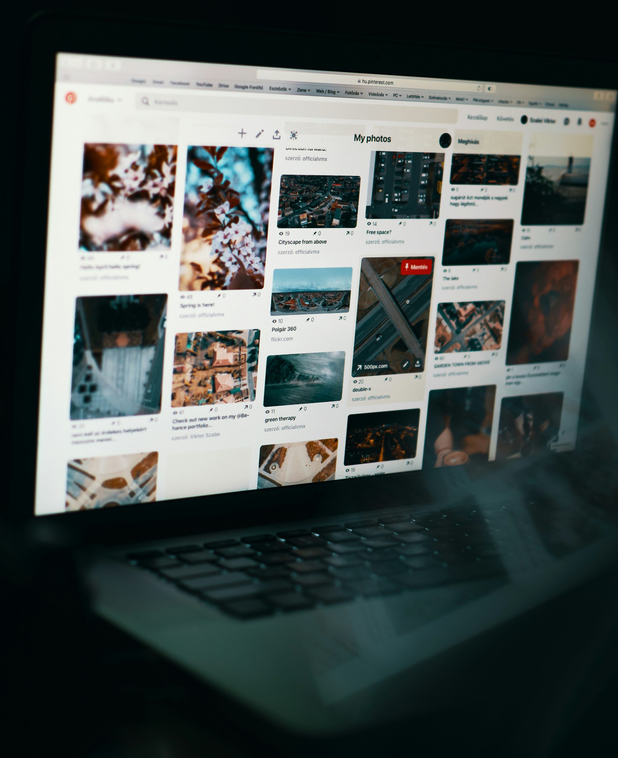 Laptop screen showing a user's Pinterest photos page with urban and nature photography.